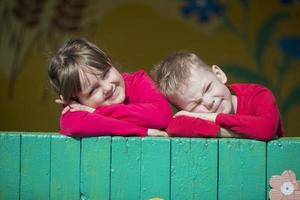 Cheerful children from kindergarten on a summer walk. Six year old boy and girl play in the garden. photo