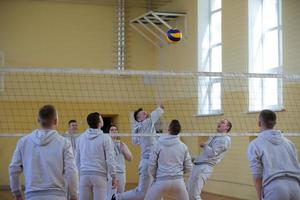 An open lesson in the college of physical education. People play volleyball in the gym. photo