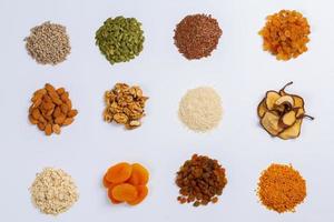 Healthy vegetarian food concept. Assortment of dried fruits, nuts and seeds on white background. Top view. photo