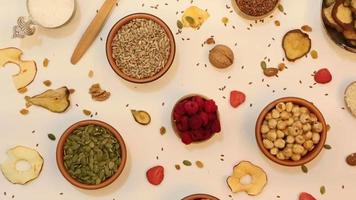 Healthy vegetarian food concept. Assortment of dried fruits, nuts and seeds on white background. Top view. video