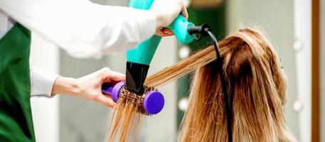 Young woman receiving drying hair photo