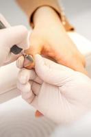 Manicurist removing old nail polish photo