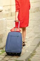 Tourist young woman pulling suitcase photo