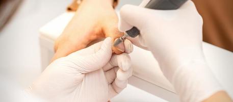 Manicurist removing old nail polish photo