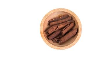 Cinnamon sticks in wooden bowl isolated on white background photo