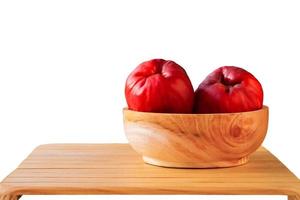 Syzygium Malaccense in a wooden bowl on a wooden table against a white background. product display photo