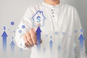 Man pressing home icon. Concept of selling house with high selling rate. photo