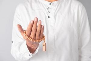 Hand of a Muslim man holding tasbih beads photo