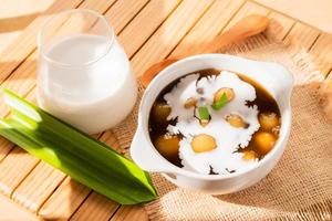 Bubur Candil or Indonesian rice flour porridge with sweet potato sticky rice balls, served with palm sugar sauce in a white bowl photo