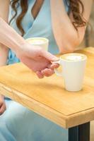 Waiter puts a cup of coffee photo