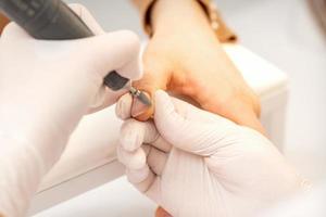 Manicurist removing old nail polish photo