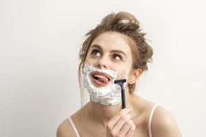 Woman shaving face with razor photo