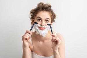 Woman shaving face with razor photo