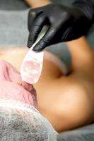 Cosmetologist applying an alginic mask photo