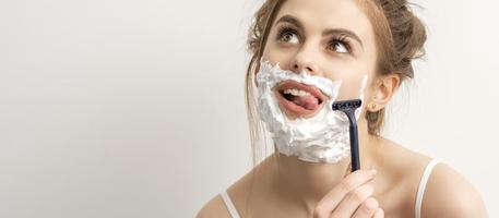 Woman shaving face with razor photo