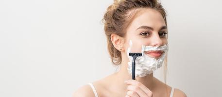Woman shaving face with razor photo