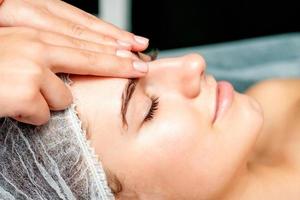 Female therapist making forehead massage photo