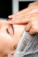 Female therapist making forehead massage photo