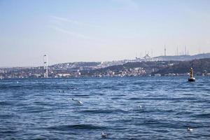 paisaje de el Estanbul bósforo con buques en eso debajo un nublado cielo en el noche foto