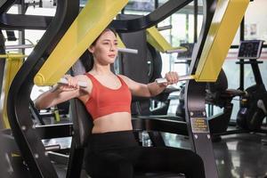 Young woman working out in the Gym with fitness machine, Beautiful woman in fitness center, Sport and fitness concepts photo