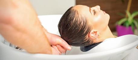 Hairdresser washing hair of client photo