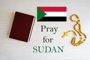 Pray for Sudan. Rosary and Holy Bible background. photo