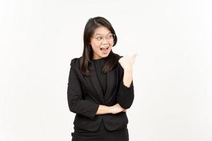 Presenting and Pointing Side Product Using Thumb Of Beautiful Asian Woman Wearing Black Blazer photo