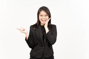 Showing Product and Pointing Side Of Beautiful Asian Woman Wearing Black Blazer Isolated On White photo