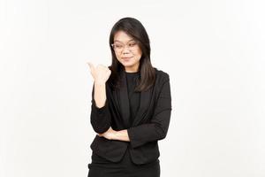 Presenting and Pointing Side Product Using Thumb Of Beautiful Asian Woman Wearing Black Blazer photo