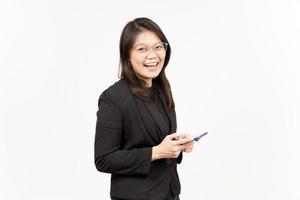 Smiling and Holding Smartphone Of Beautiful Asian Woman Wearing Black Blazer Isolated On White photo