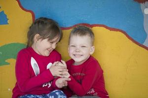 Cheerful children from kindergarten on a summer walk. Six year old boy and girl play in the garden. photo