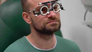 Man at the reception of an ophthalmologist. Eye examination and selection of spectacle lenses video