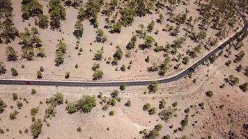 Aerial view on car driving through autumn forest road. Scenic autumn landscape video