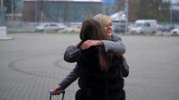 Long-awaited meeting of two friends at the airport. Slow motion video