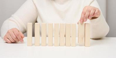 Wooden blocks on the table, a woman's hand holds one. The concept of finding unique, talented employees photo