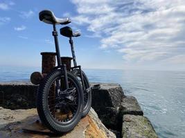 Couple unicycles at the sea side photo