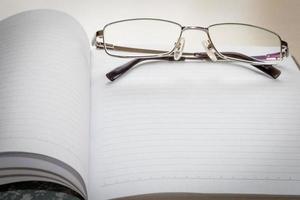 Eyeglasses and Notepad with blank page photo