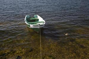 empty rowing boat on the water on a summer day photo