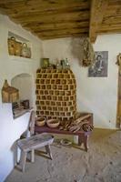 historic farmhouse interior in a museum with an old tiled stove in the corner photo