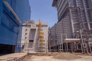 aerial view of combine cycle project power plant when day time with blue sky and cloudy vibes. The photo is suitable to use for industry background photography, power plant poster and electricity.