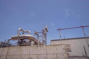 aerial view of combine cycle project power plant when day time with blue sky and cloudy vibes. The photo is suitable to use for industry background photography, power plant poster and electricity.