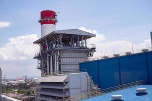 aerial view of combine cycle project power plant when day time with blue sky and cloudy vibes. The photo is suitable to use for industry background photography, power plant poster and electricity.