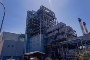 aerial view of combine cycle project power plant when day time with blue sky and cloudy vibes. The photo is suitable to use for industry background photography, power plant poster and electricity.