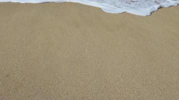 água espuma com suave areia. onda e areia às a tropical de praia. de praia ondas lento movimento vídeo video