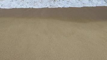 agua espuma con suave arena. ola y arena a el tropical playa. playa olas lento movimiento vídeo video