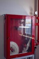 Indoor hydrant box with white hose, nozzle and valve on the office area. The photo is suitable to use for industry background and fire fighter content media.