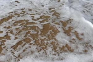 Water foam with smooth sand. photo