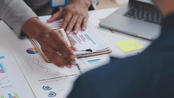 Financial analysts analyze business financial reports on a digital tablet planning investment project during a discussion at a meeting of corporate showing the results of their successful teamwork. video