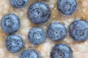 close up of oatmeal porridge with honey and blueberries photo