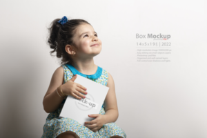 Little girl  holding a small cubical box in hands psd